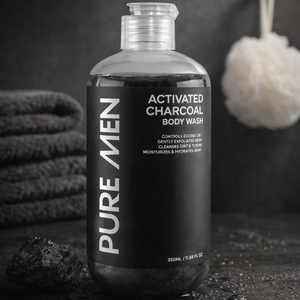 Bottle of Pure Men Activated Charcoal Body Wash with towels and a loofah in the background.