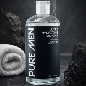 Bottle of Pure Men Ultra Hydrating Bodywash on a dark background with a towel and soap.